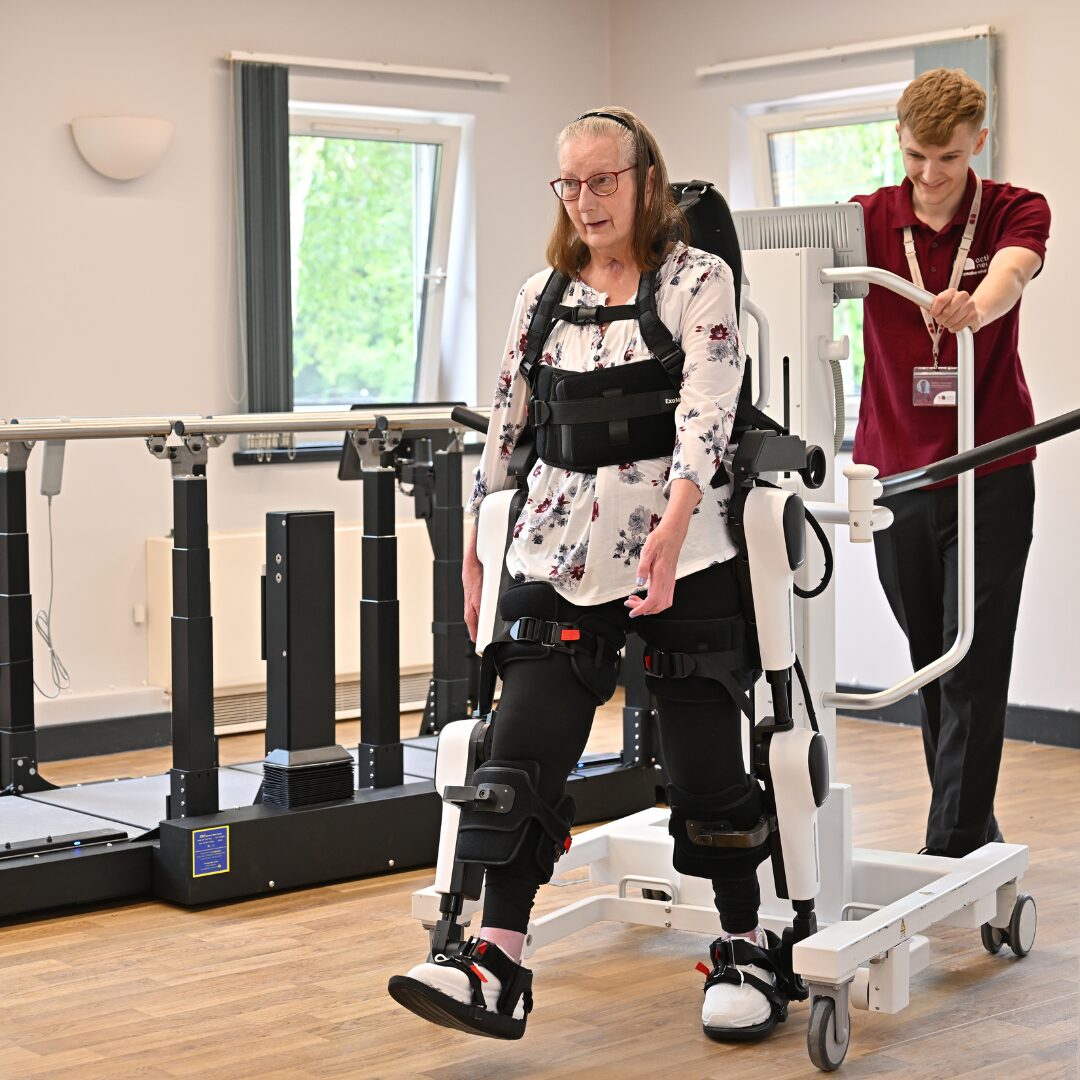 Therapists supporting a client on the exoskeleton